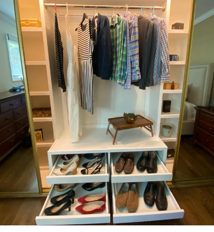 Custom white closet featuring multiple shoe drawers, hanging storage for clothes, and a center display area.